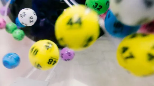 Gros plan dynamique de boules de loto color&eacute;es et num&eacute;rot&eacute;es en plein mouvement, cr&eacute;ant un effet de flou artistique.